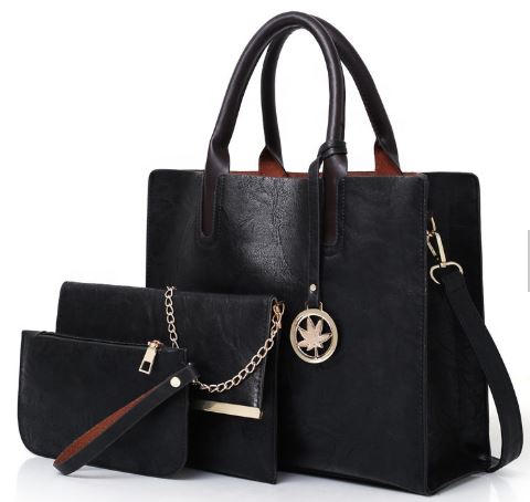  Image of a black three piece purse set including a  Large Tote Bag with handles and shoulder strap, a Clutch Bag mid-size bag (with chain strap) and a  Wallet sized accessory bag 