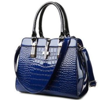 Image of a women's blue designer crocodile patent leather handbag.