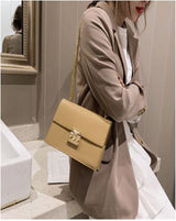 Image of a woman with a women's chain strap brown leather shoulder bag on her shoulder.