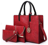  Image of a red three piece purse set including a  Large Tote Bag with handles and shoulder strap, a Clutch Bag mid-size bag (with chain strap) and a  Wallet sized accessory bag 